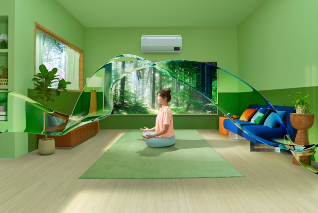'A young woman and a girl do yoga while the WindFree air conditioner cools the room. Its PM 1.0 filter traps ultra-fine particles to maintain good air quality.